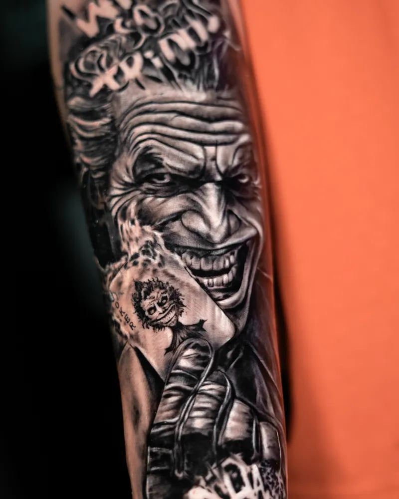A forearm: a grinning clown with WHY SO SERIOUS lettered above him