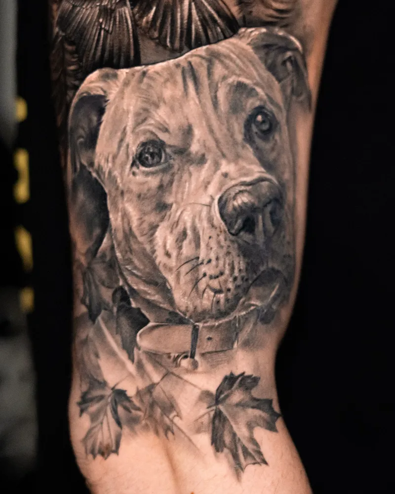 A healed forearm: a pit bull's head in a collar, with maple leaves below it