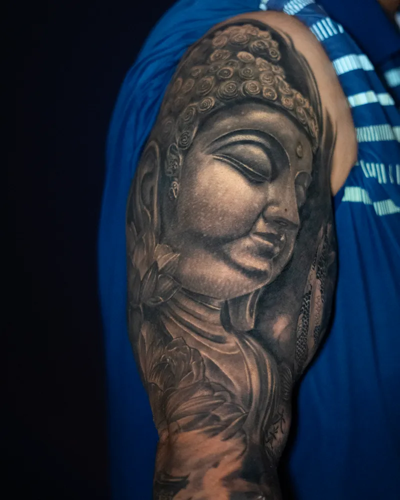 A healed upper arm: a Buddha's face with lotus flowers beneath it