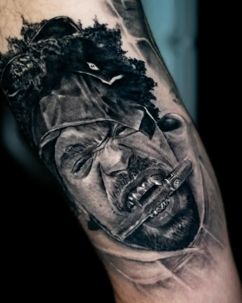A healed forearm: a scowling man with a cigar in his teeth, a dark wolf's head above him