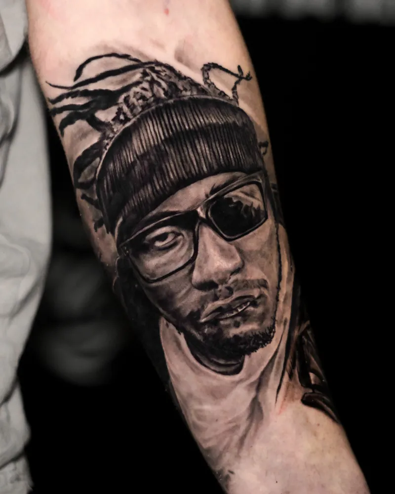A healed forearm portrait of a man in a beanie and dark sunglasses